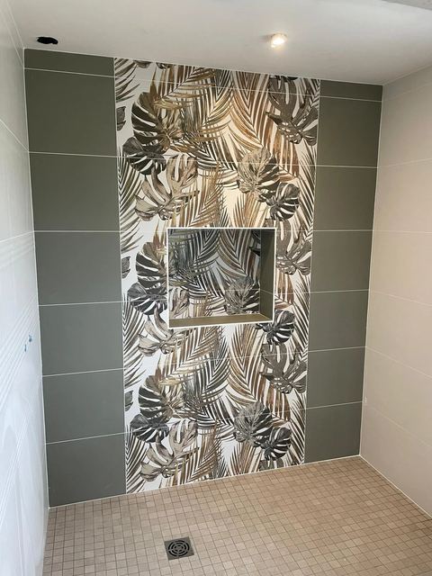 Douche avec niche carrelée à motif de feuillage tropical et faïence vert sauge