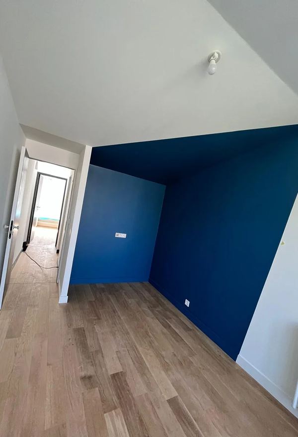 Chambre terminée avec mur bleu et parquet