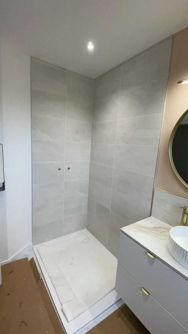 Douche carrelée en beige, meuble vasque blanc