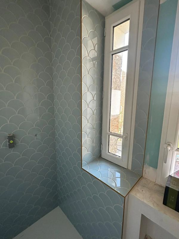 Douche à l'italienne en faïence écailles, fenêtre et miroir