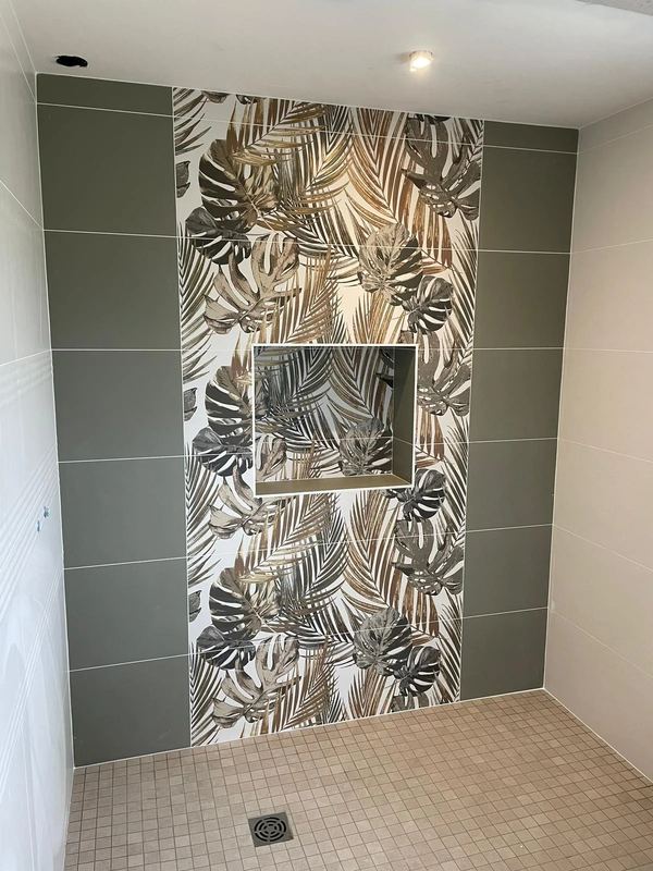 Douche avec niche carrelée à motif de feuillage tropical et faïence vert sauge