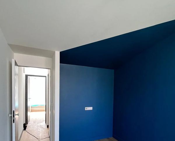 Mur bleu sous pente et porte, pièce terminée
