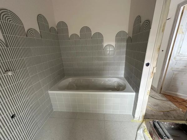 Salle de bain en cours de chantier, mosaïque écailles posée autour de la baignoire