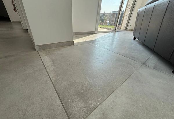 Sol en carrelage grand format gris devant une baie vitrée