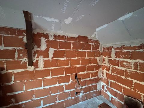 Mur en briques monté avant enduit, plaques de plâtre au plafond