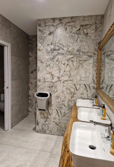 Salle de bain avec mur en carrelage effet marbre et double vasque